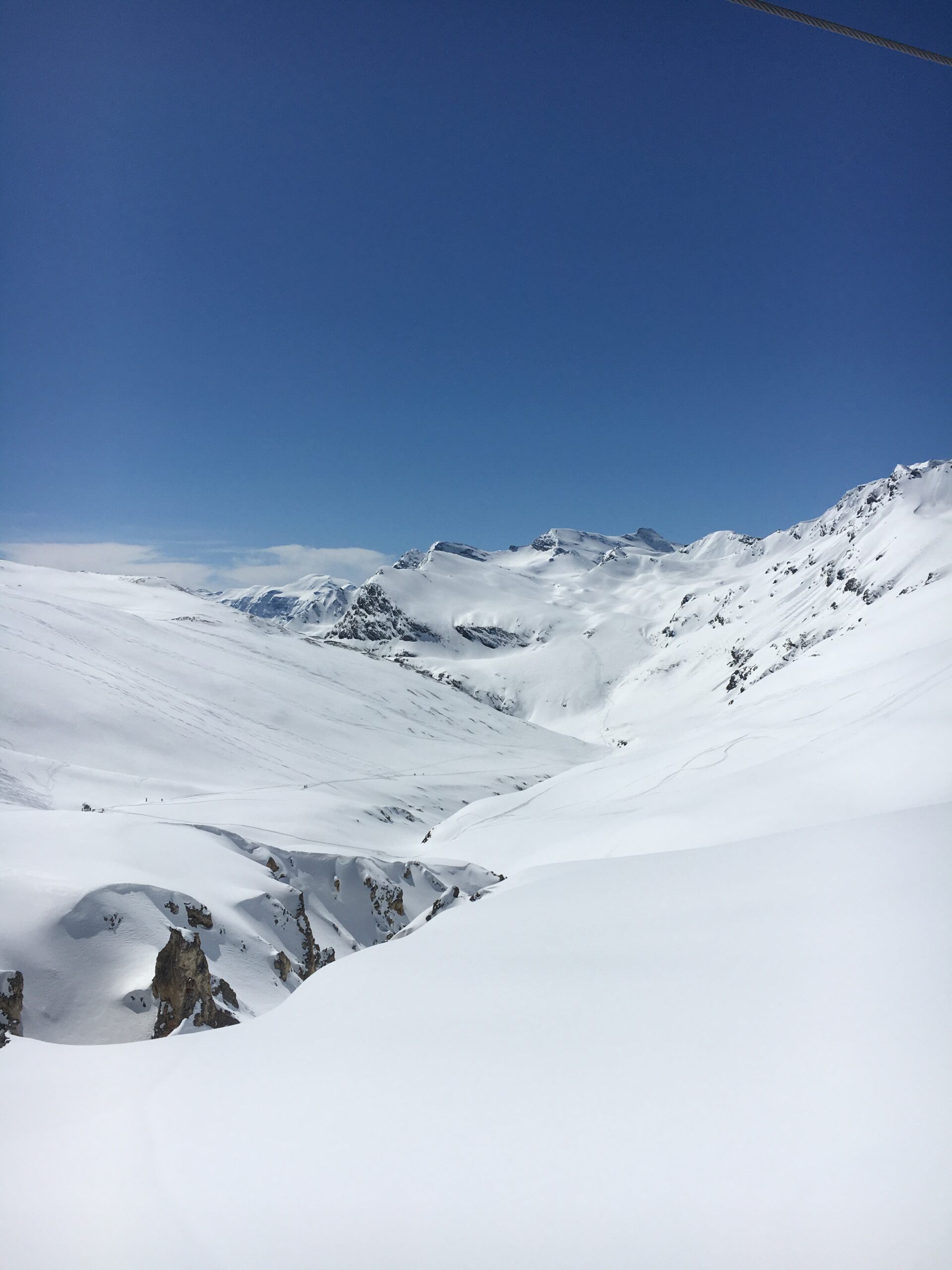 A wide snow basin opening between high peaks