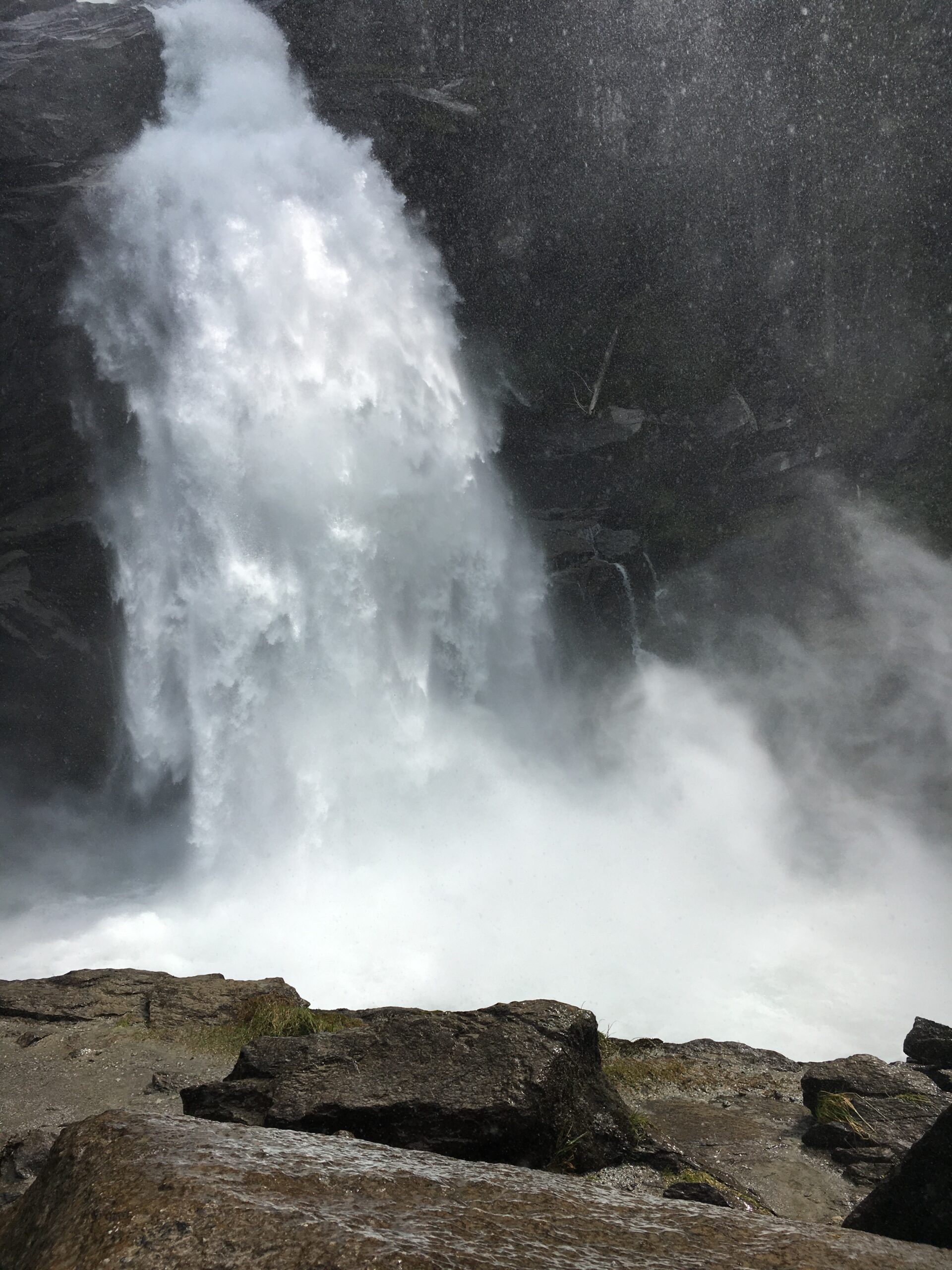 A mountain waterfall plunging into a forested ravine